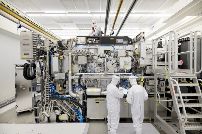 ASML staff work on the assembly of a semiconductor lithography tool
