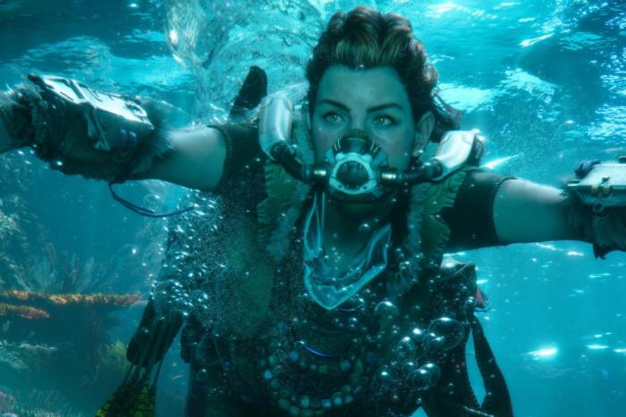 A person heavily laden with chunky necklaces swims underwater