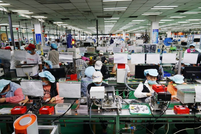 Employees oeprate machinery at a Foxconn factory