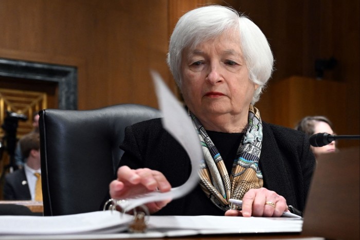 Janet Yellen turns a page in a lever arch file as she sits in the senate